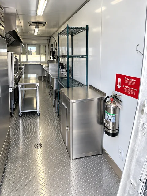 Mobile kitchen interior with stainless preparation counters and commercial equipment